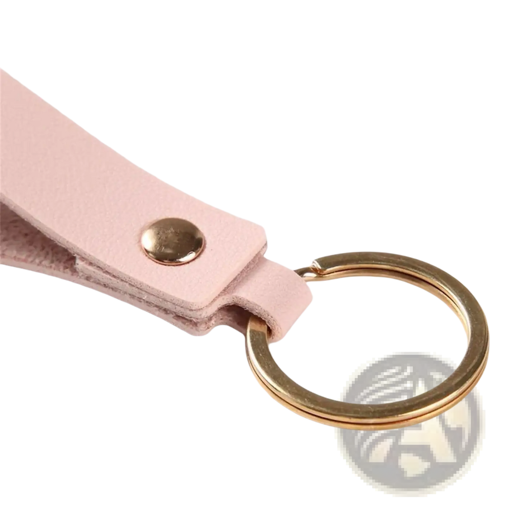 A delicate pink pu leather keychain with gold-toned metal ring and button for fashion metal keyring use