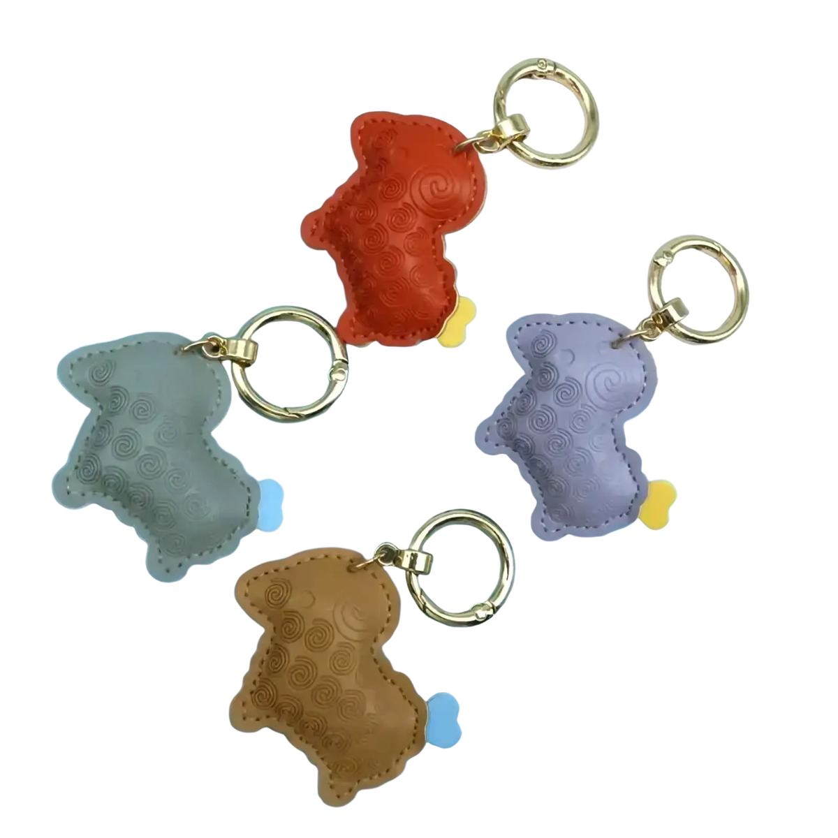 A set of four colorful pu leather sheep keychain bag charms embossed with dog shapes in gray orange purple and brown