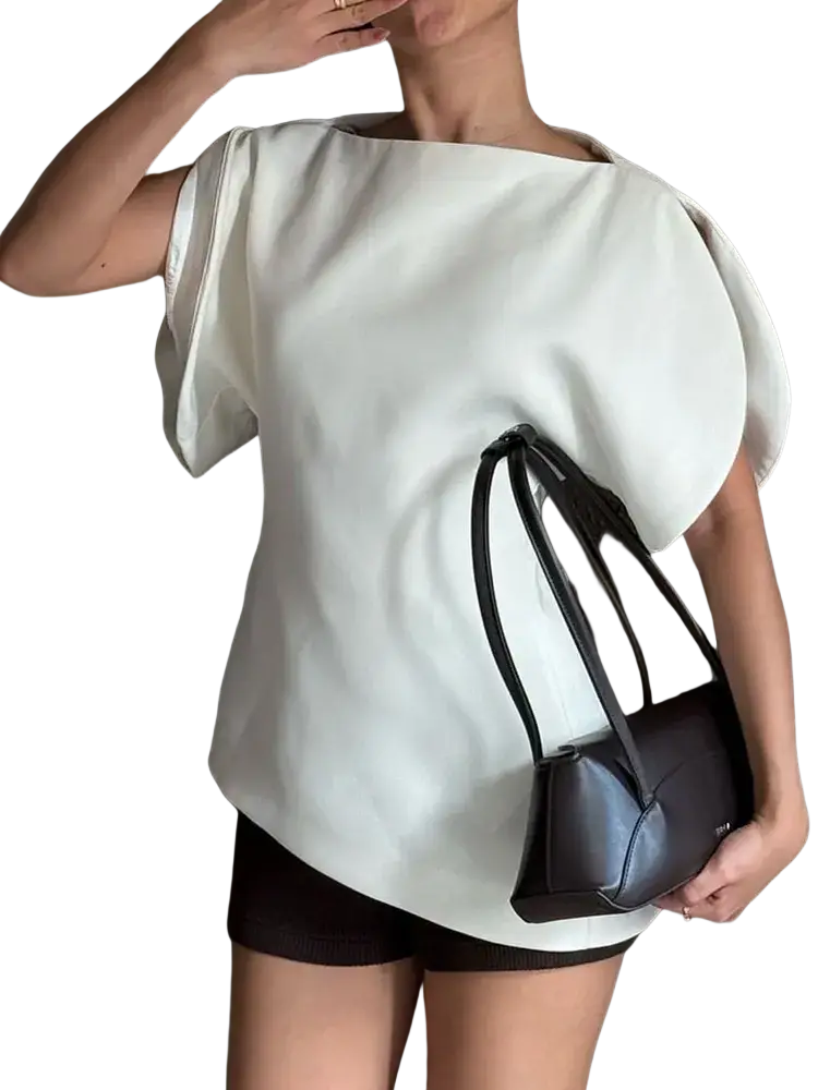 Black leather mini handbag with structured angular design and thin handles paired with a white puff sleeve blouse