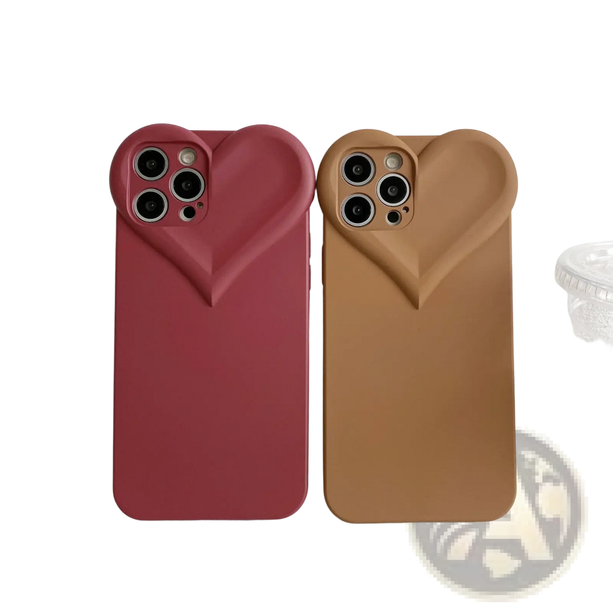 Two puffy heart silicone iPhone cases in matte red and tan with soft material and precise camera cutouts shown from the back