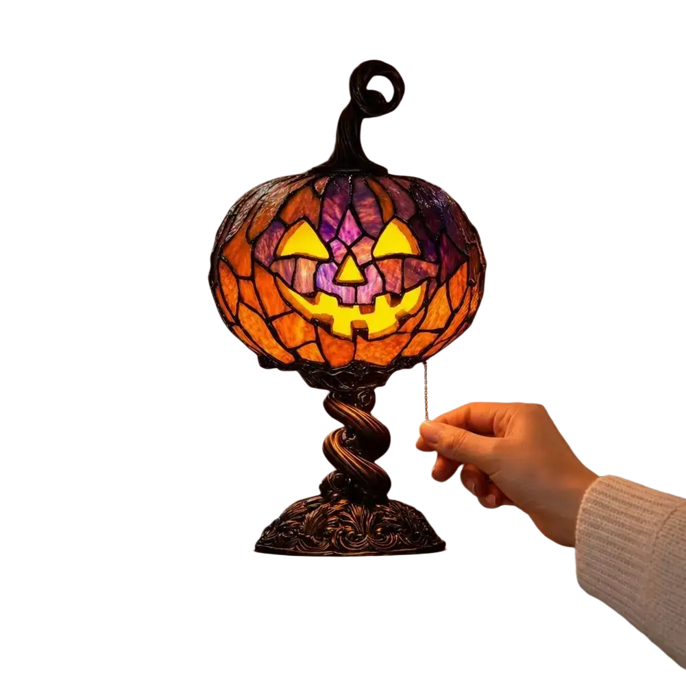 Halloween-themed pumpkin table lamp with stained glass jack-o-lantern design and ornate dark metal base