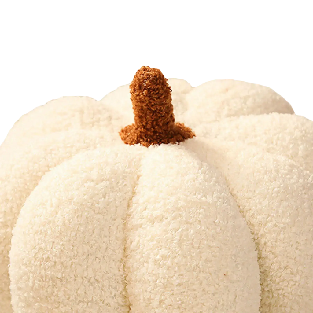 Cream plush halloween pumpkin throw pillow with textured fuzzy surface and brown tufted stem for seasonal decor
