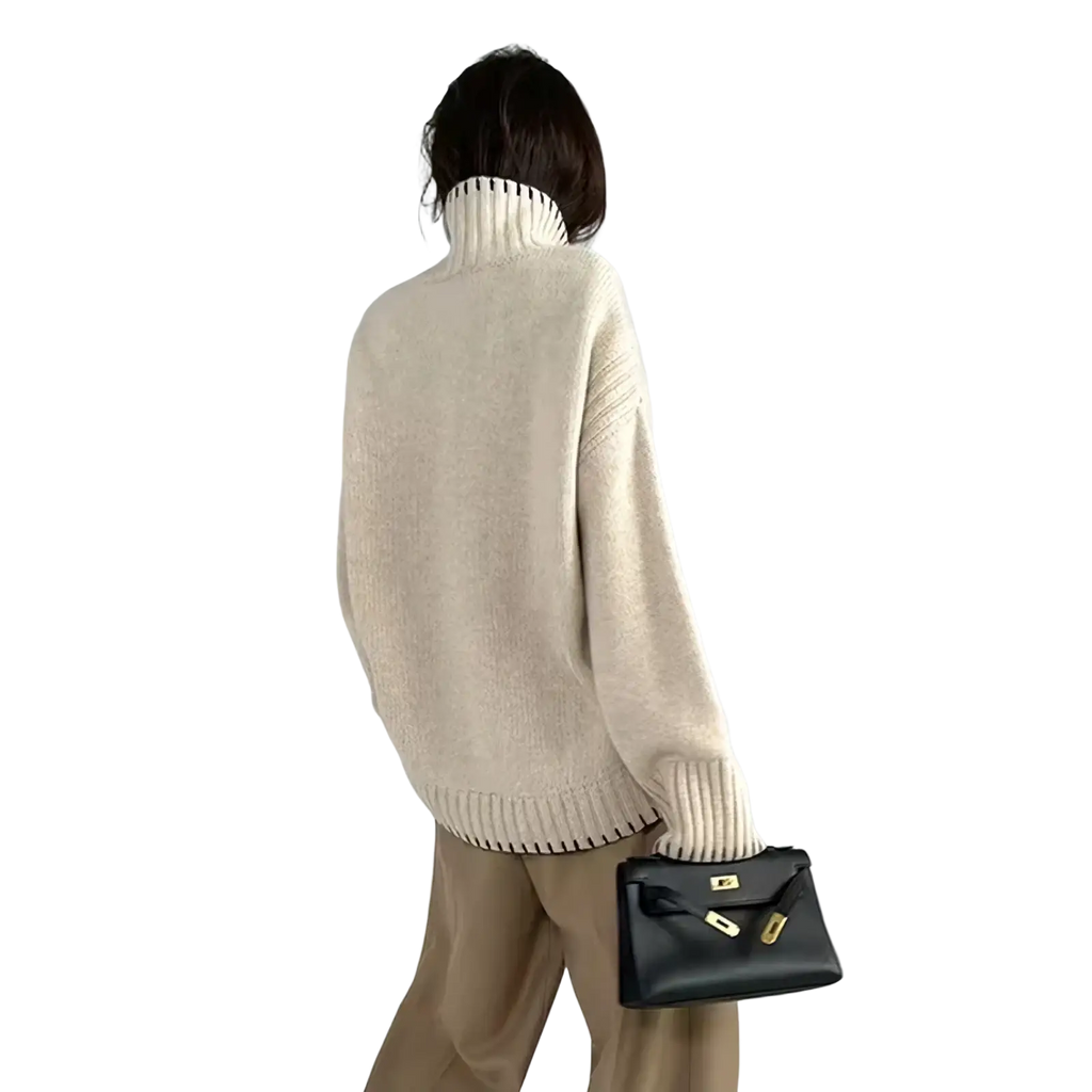 A black leather handbag with gold-tone hardware and a minimalist design paired with a pure wool turtleneck sweater women