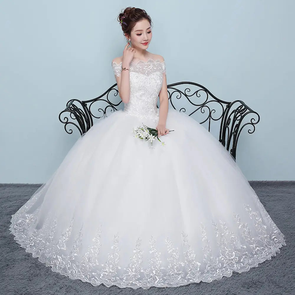 White off the shoulder wedding gown with intricate lace detailing and voluminous tulle skirt by Qidi Lace