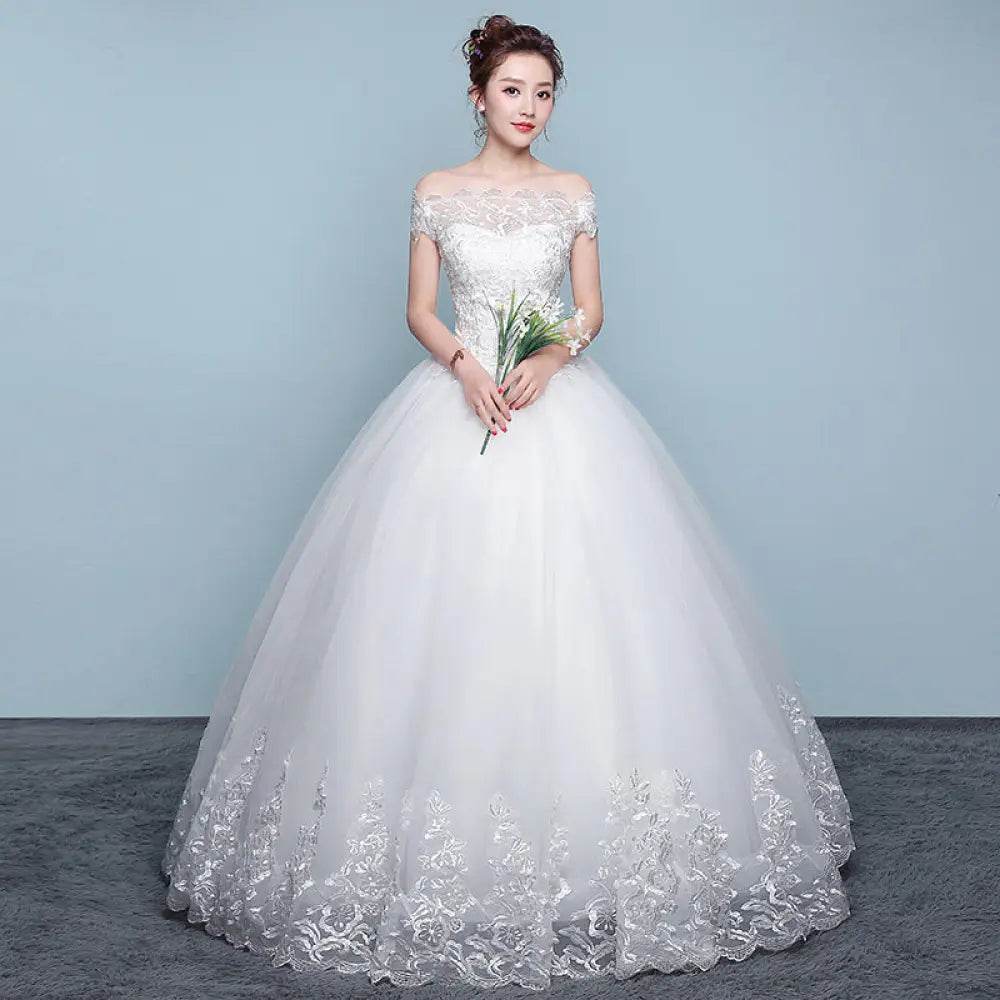 A white qidi lace off the shoulder wedding dress with intricate lace detailing and a voluminous tulle ball gown skirt