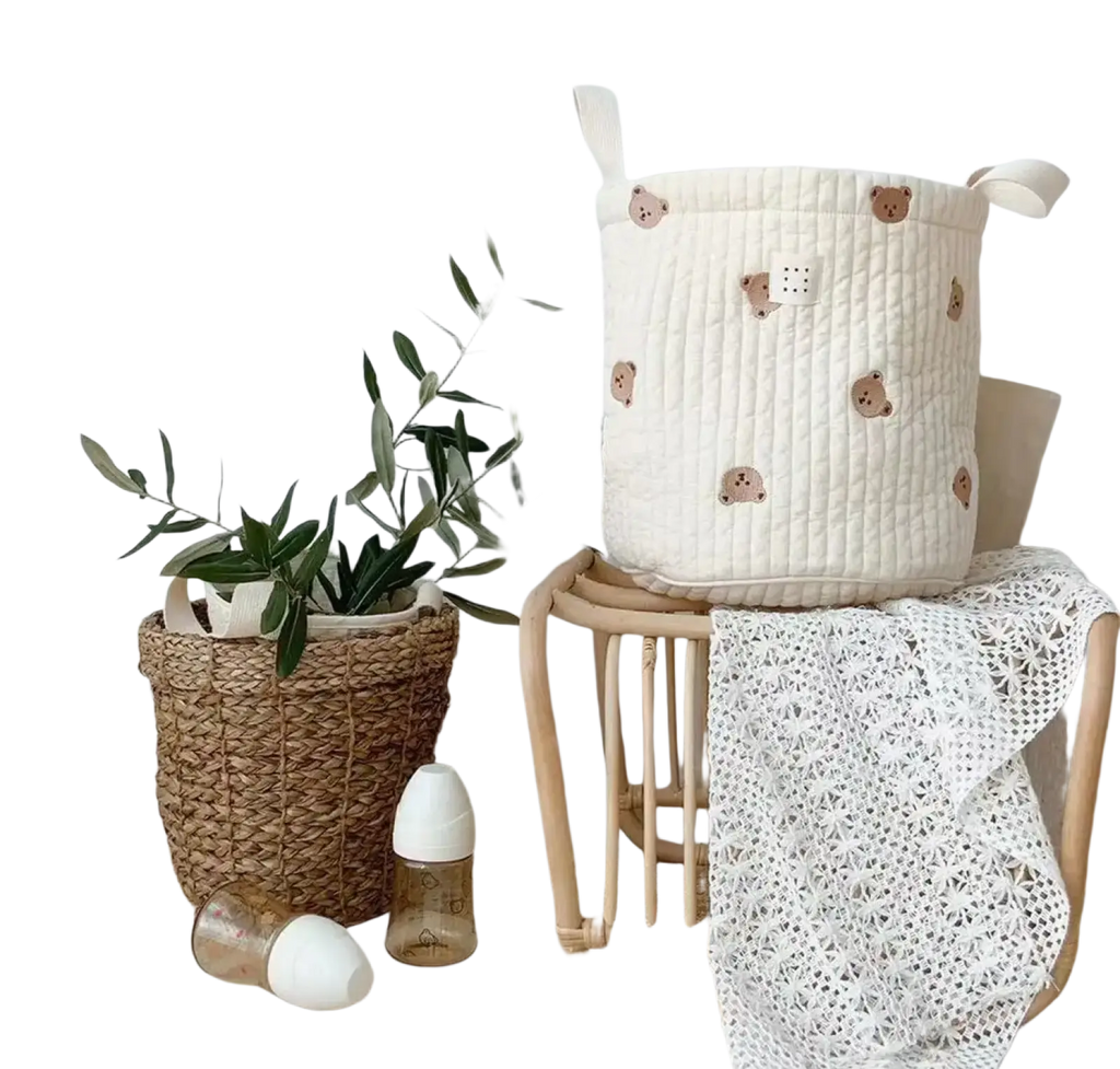 Cream-colored quilted baby diaper storage basket with embroidered brown bear faces and fabric handles for organization