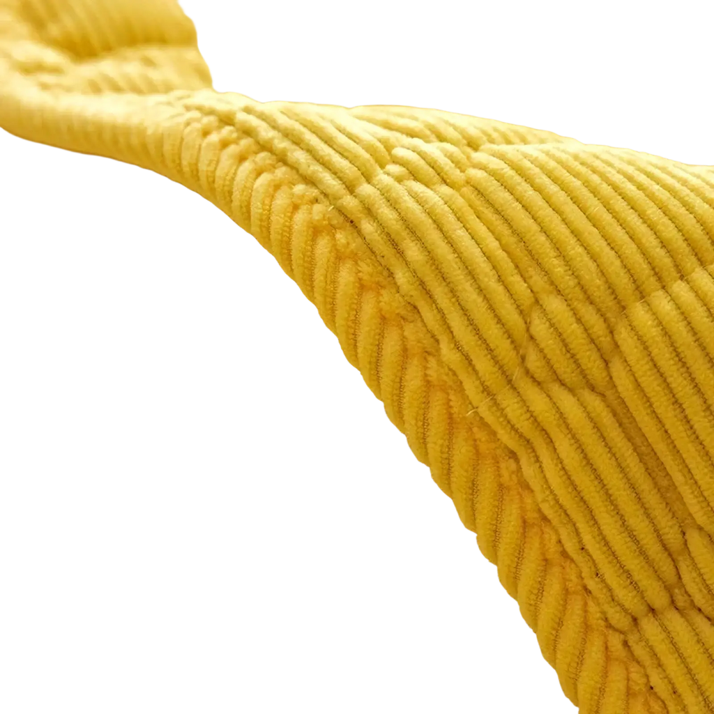 A mustard-yellow corduroy quilted non slip sofa cover protector with soft ribbed texture and subtle quilting pattern