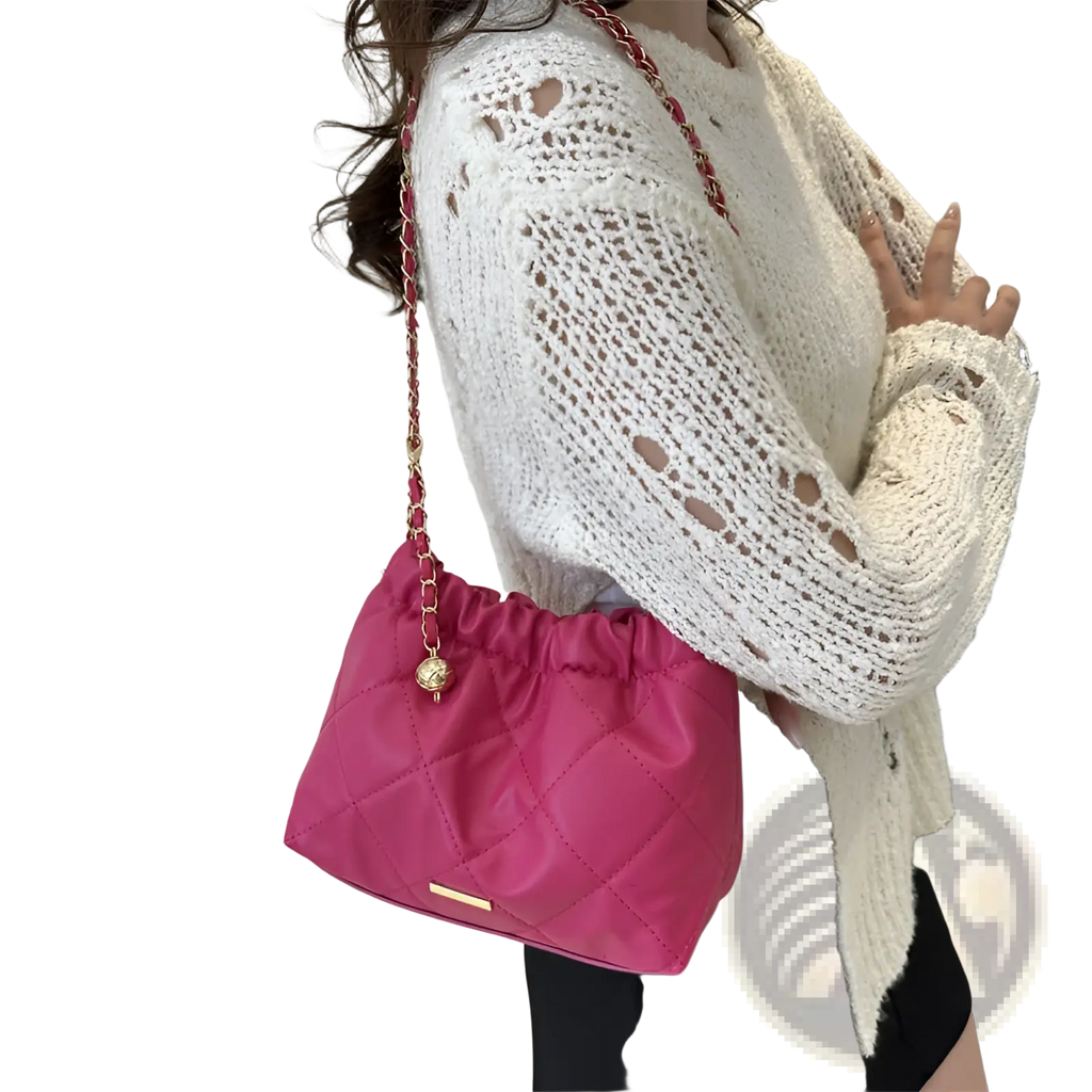 Vibrant pink quilted faux leather crossbody bag with red and gold chain strap and golden ball charm