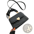 Black quilted crossbody bag with a gold heart clasp and ruched black handle for stylish everyday use