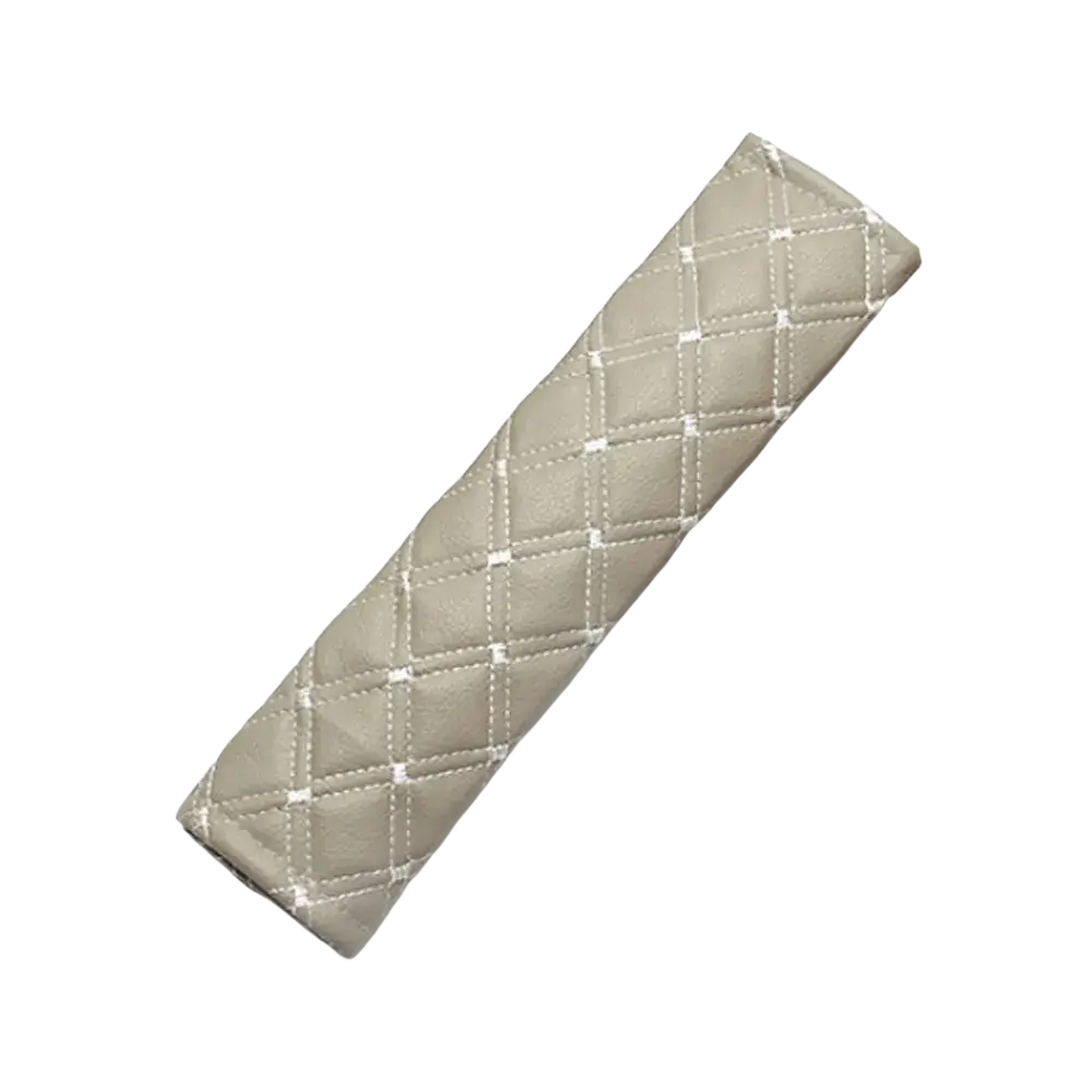 Beige quilted leather car seat belt pad with white stitching designed for comfort and protection while driving