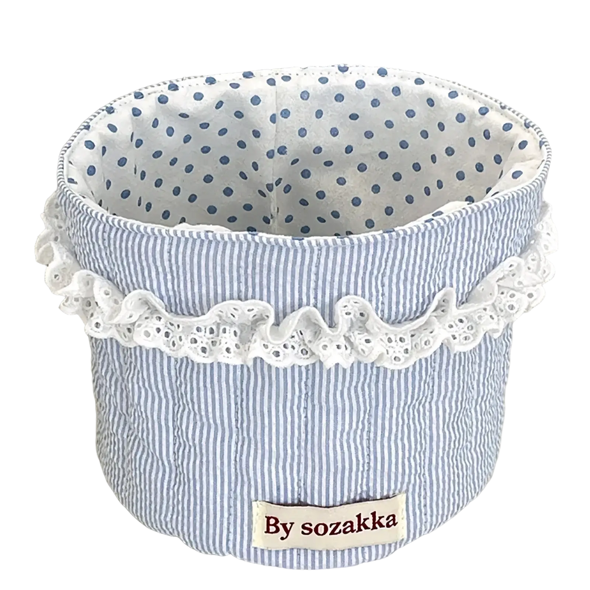 Quilted nursery storage basket in blue and white striped fabric with delicate lace trim around the rim