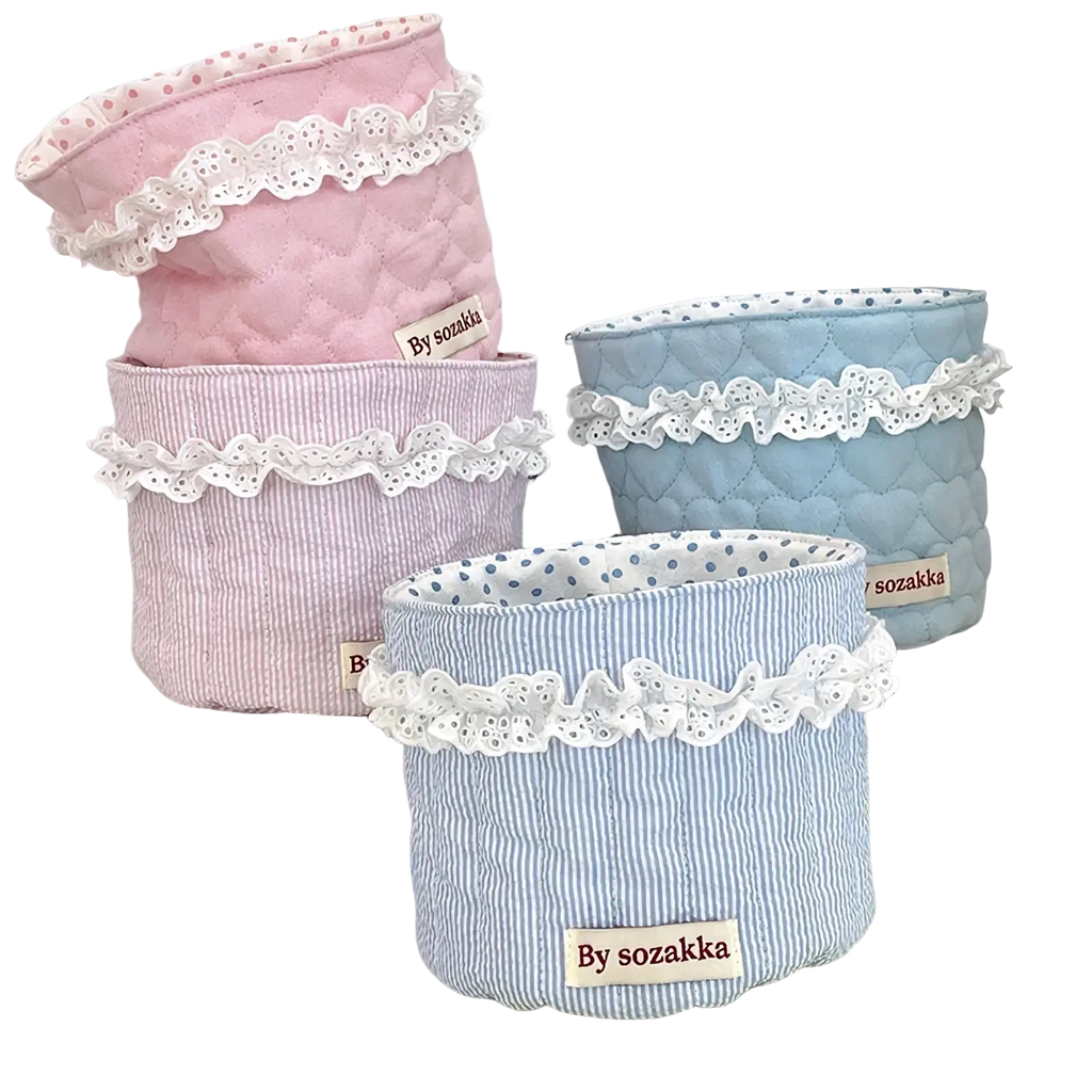 Quilted nursery storage baskets in pastel pink and blue fabric with white lace trim for organized storage