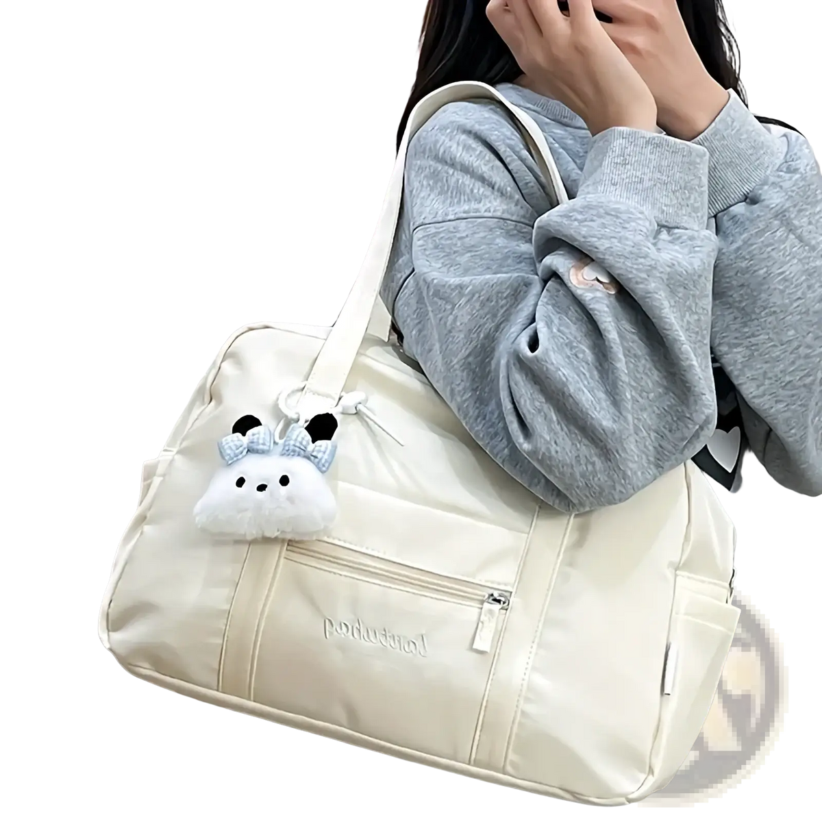 Cream-colored quilted nylon travel tote bag with shoulder strap and plush white bunny charm with black ears and blue bow
