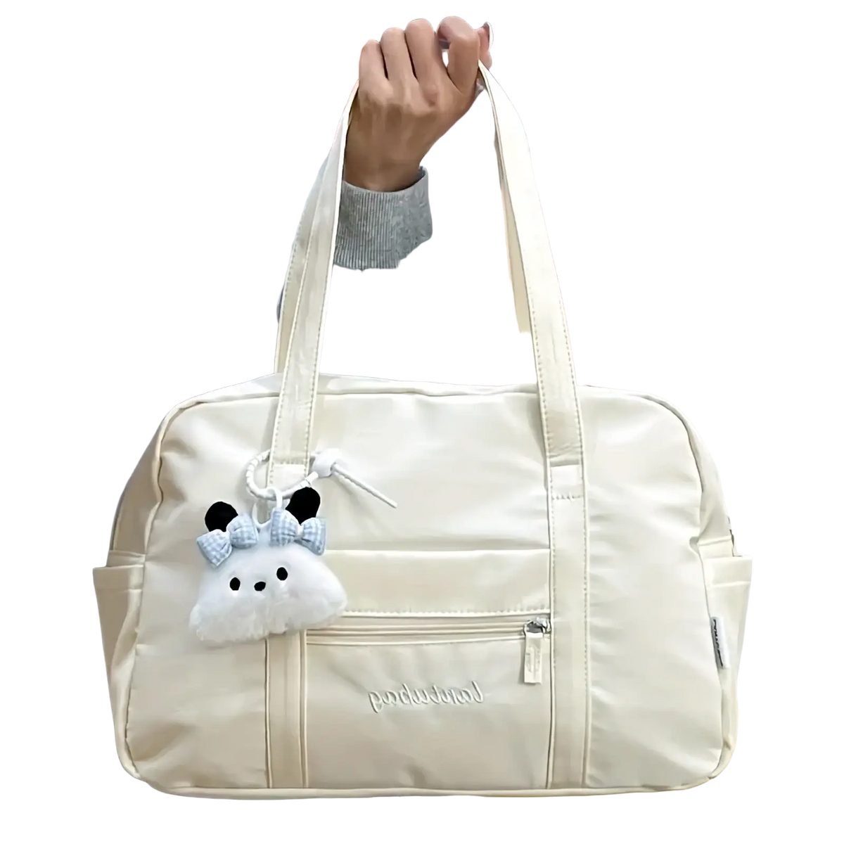 Cream-colored quilted nylon travel tote bag with soft texture and plush panda charm hanging from the handle