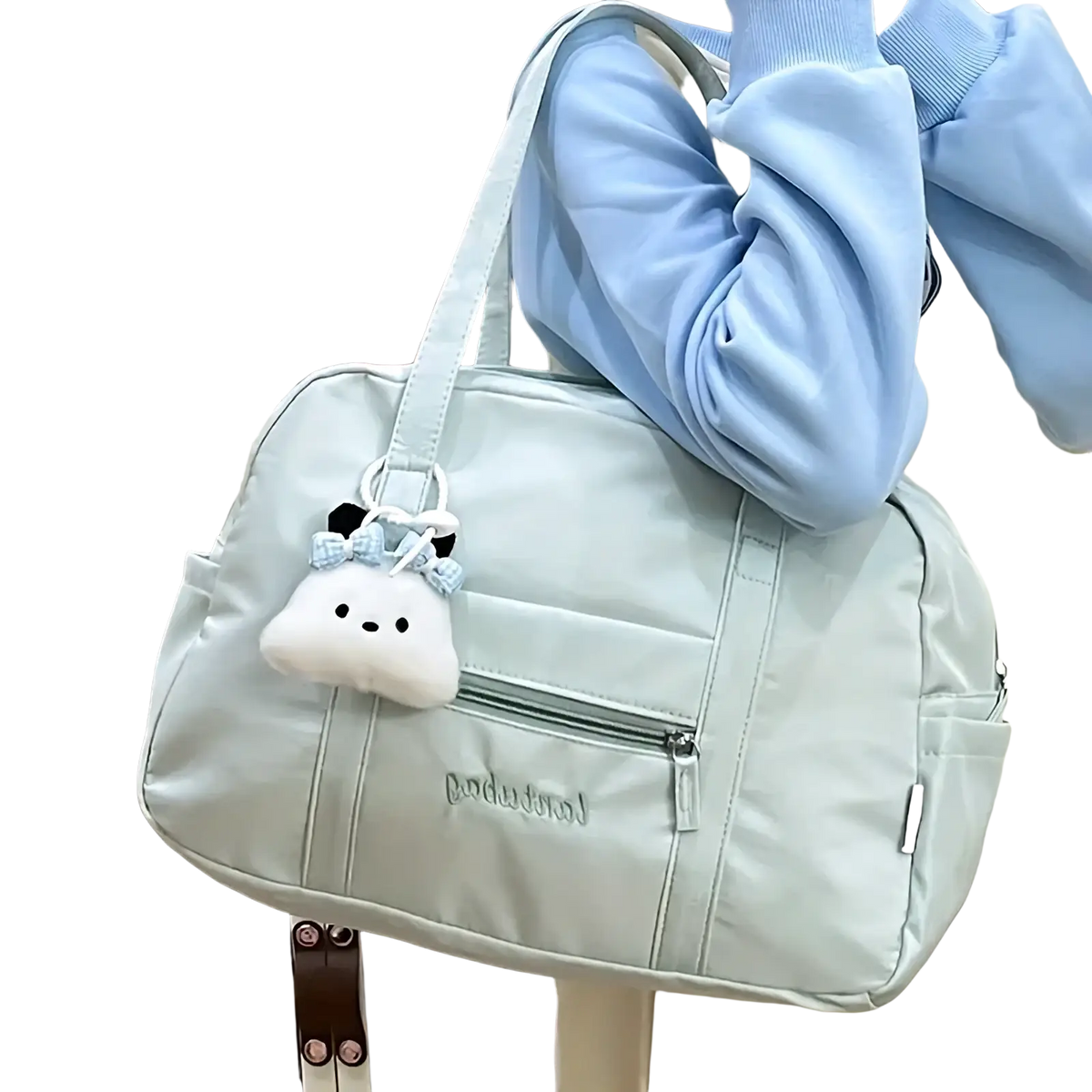 Light blue quilted nylon travel tote bag with white plush cloud charm hanging from the handle