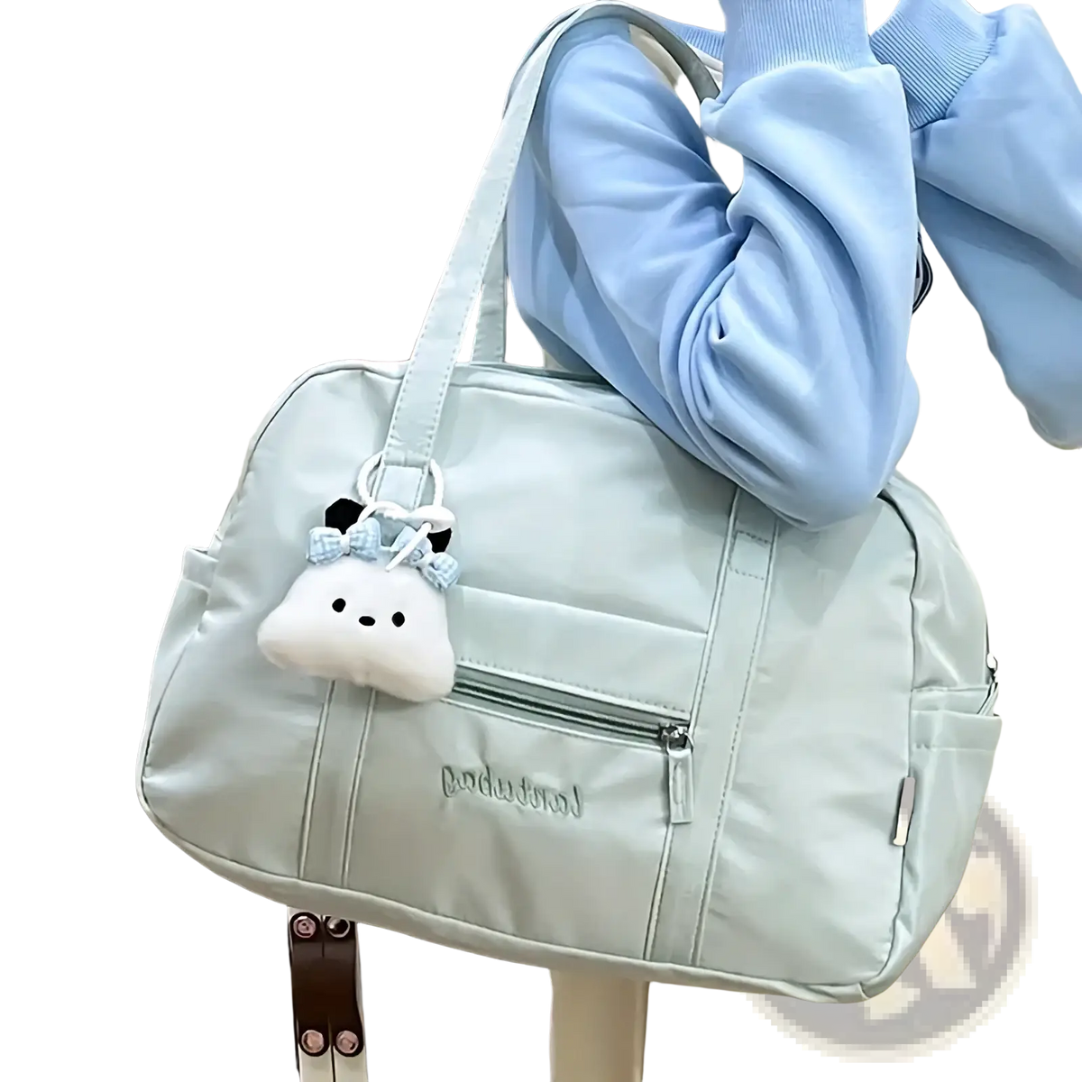 Light blue quilted nylon travel tote bag with white plush cloud charm hanging from the handle