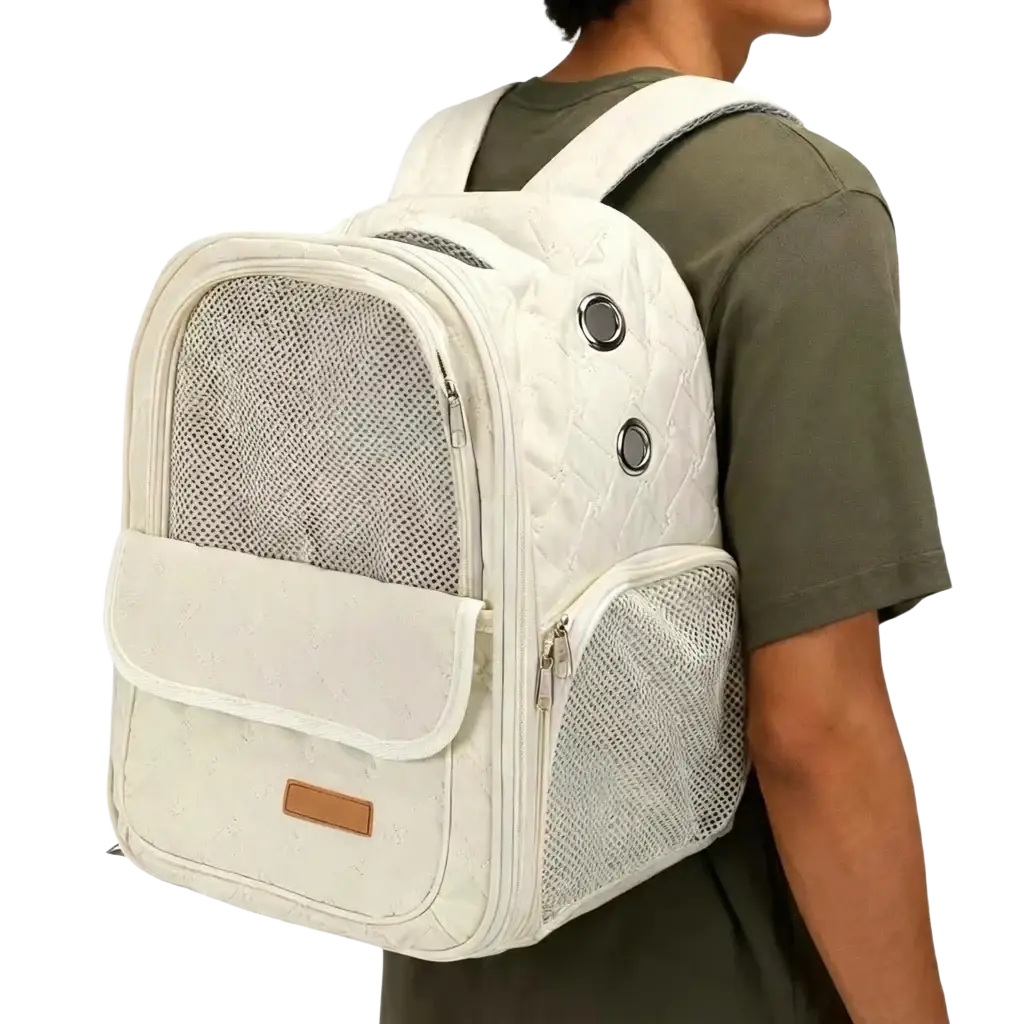 Cream-colored quilted pet carrier backpack for small dogs with mesh panels and silver-toned metal accents