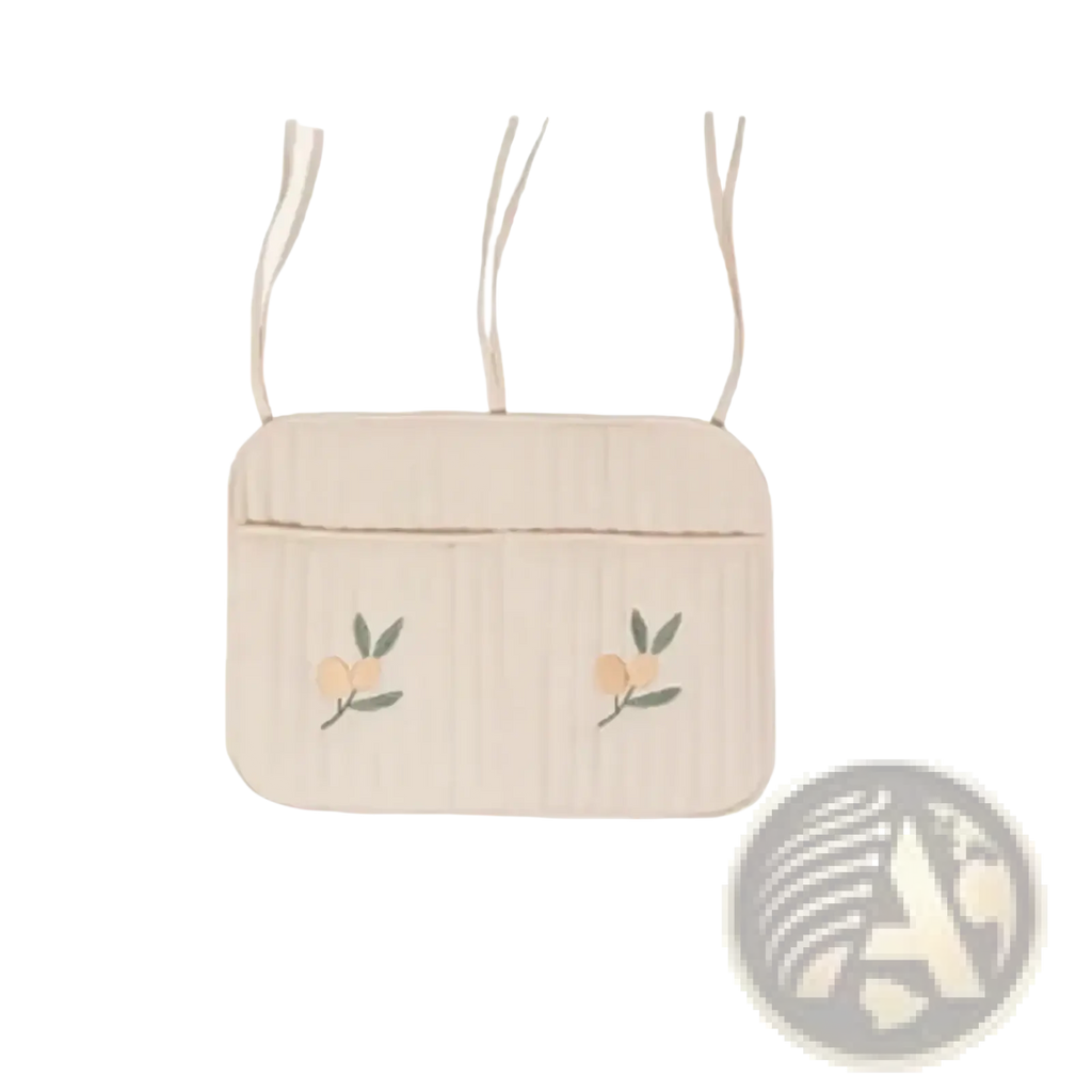 Beige quilted stroller organizer bag with embroidered peach motifs and matching fabric straps in crossbody style