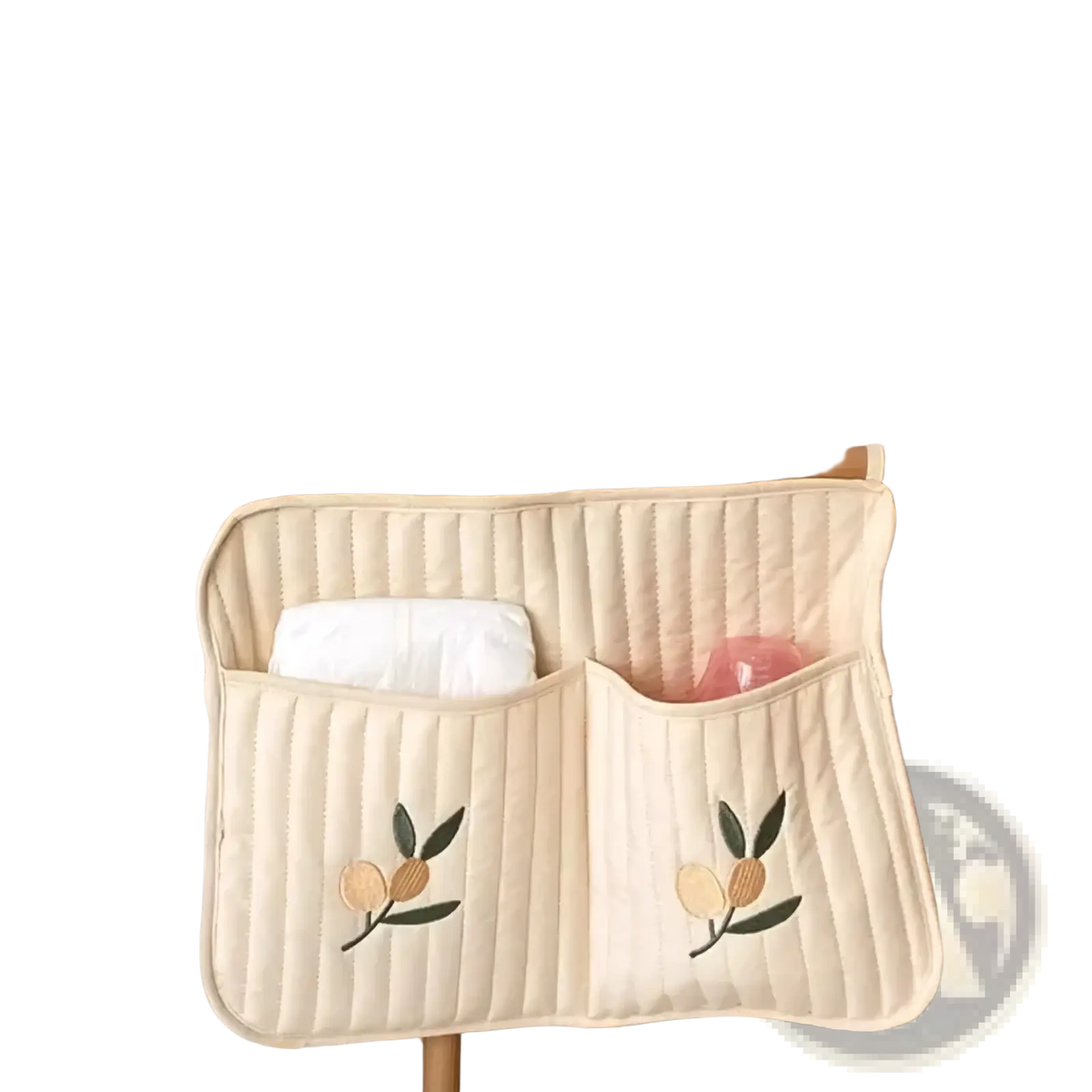 Cream-colored quilted stroller organizer bag with embroidered peach and leaf motifs and two pockets for baby essentials