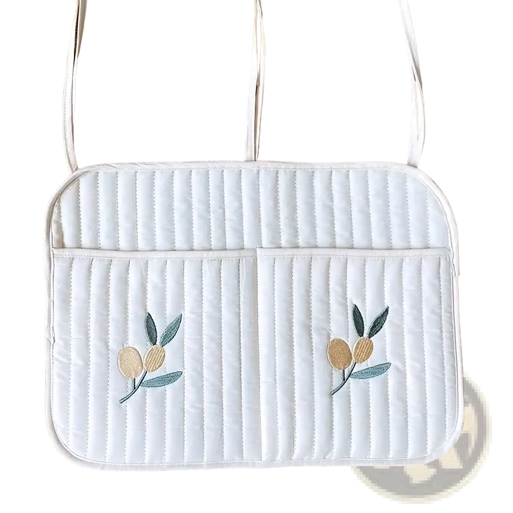White quilted laptop sleeve with embroidered olive branch motifs and matching shoulder straps for stroller organizer bag