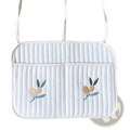 White quilted laptop sleeve with embroidered olive branch motifs and matching shoulder straps for stroller organizer bag