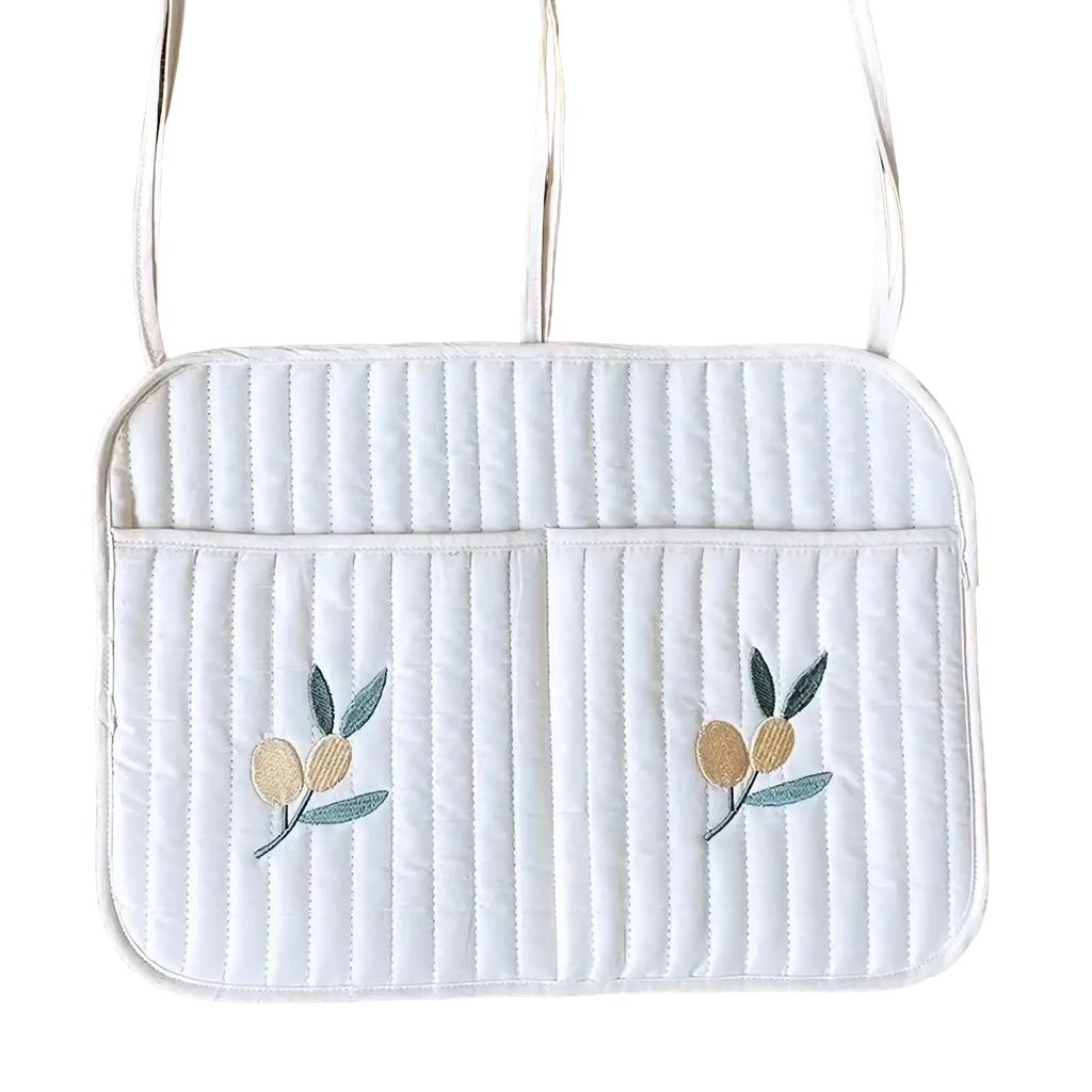 White quilted laptop sleeve with embroidered olive branch motifs and matching shoulder straps for stroller organizer bag