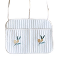 White quilted laptop sleeve with embroidered olive branch motifs and matching shoulder straps for stroller organizer bag
