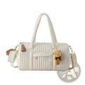 Cream-colored quilted stroller organizer bag with black polka dots featuring plush teddy bear charm and tassel accents
