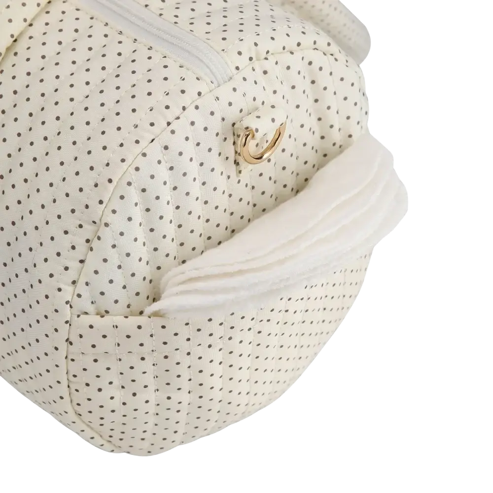 Cream-colored quilted stroller organizer bag with black polka dots and gold-tone metal clasp featuring teddy bear design