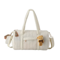 Cream-colored quilted stroller organizer bag with black polka dots featuring plush teddy bear charm and tassel accents