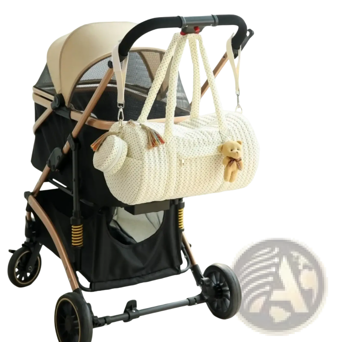 Cream-colored knitted quilted stroller organizer bag with polka-dot pattern and teddy bear charm on handle