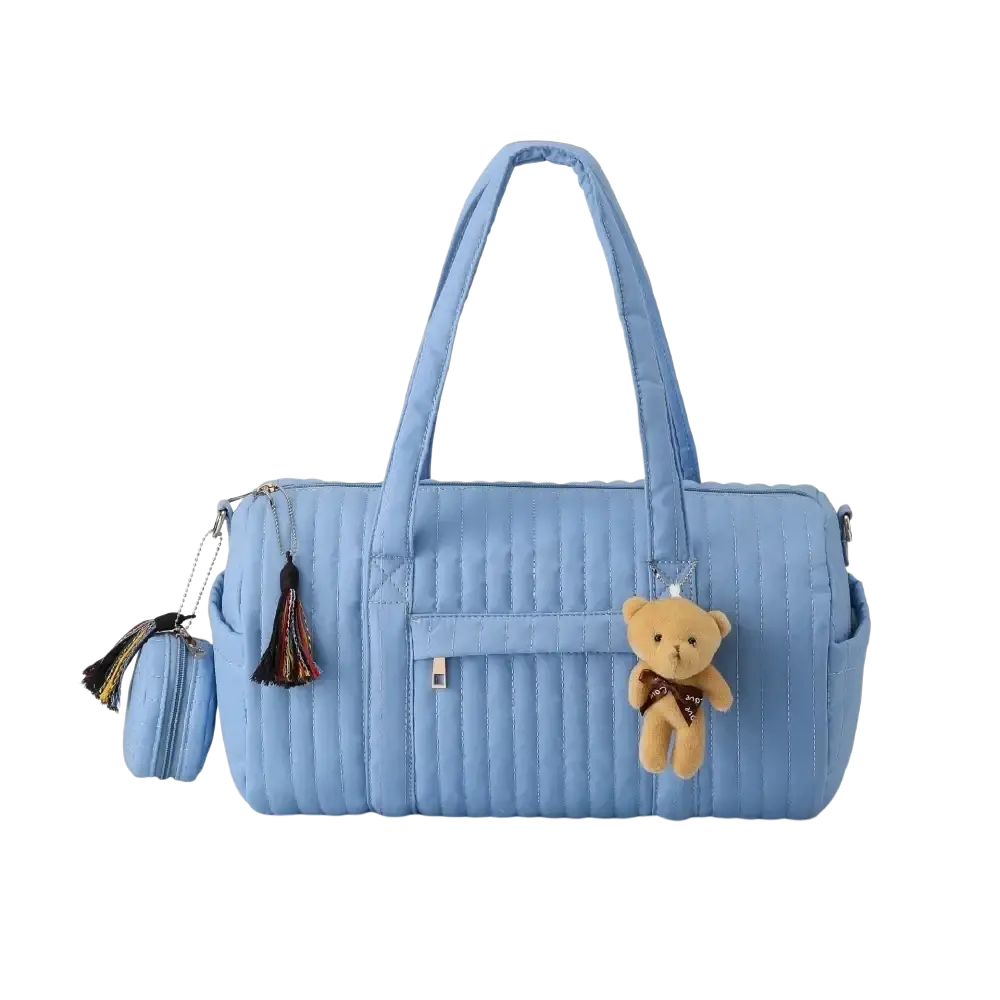 Light blue quilted stroller organizer bag with matching handles and tan teddy bear charm on the front