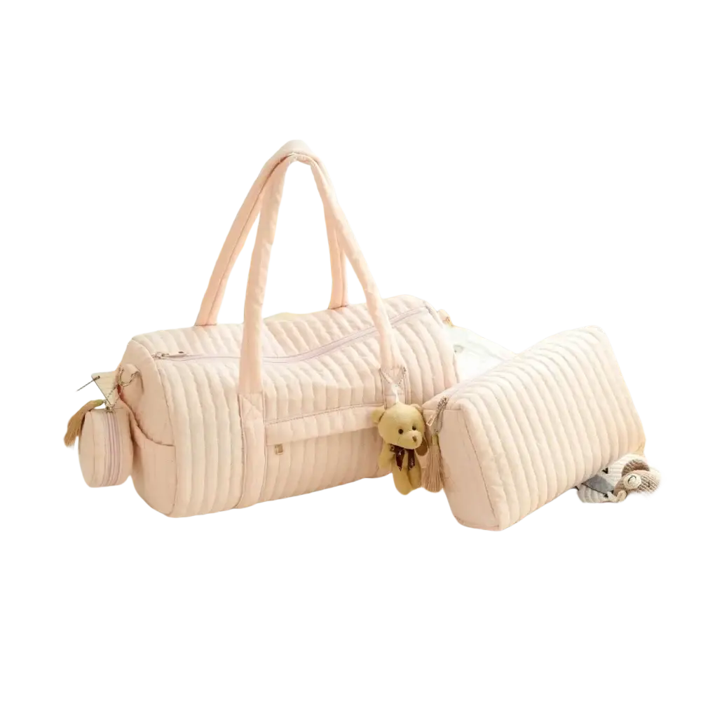 Pink quilted stroller organizer bag with matching handles and a small teddy bear charm accessory
