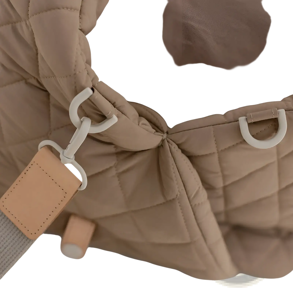 Beige quilted travel pet carrier bag featuring a puffer jacket style with white plastic hardware and tan leather tag