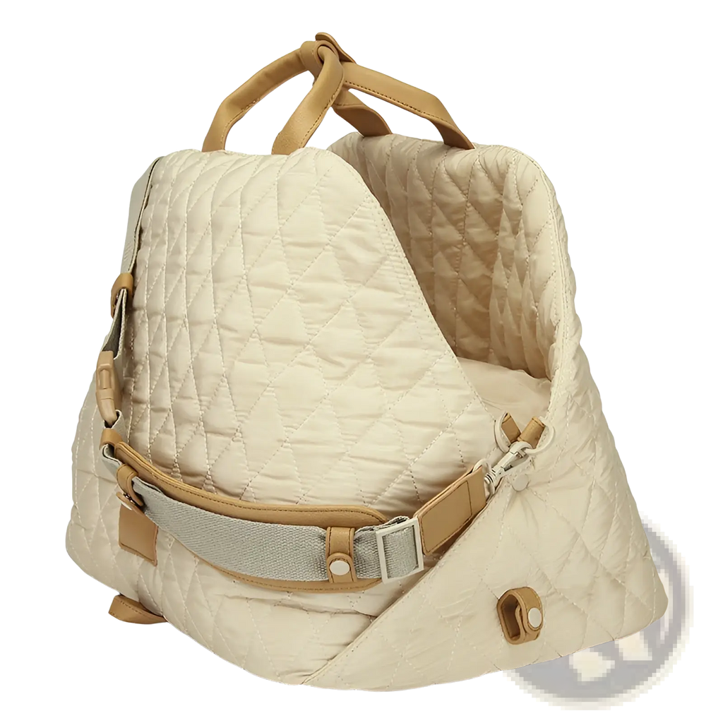 Cream-colored quilted travel pet carrier bag with tan leather handles and straps for comfortable carrying