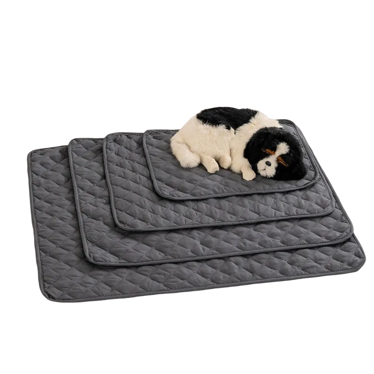 Set of three gray quilted waterproof washable pet mats with diamond stitch arranged by size on light couch