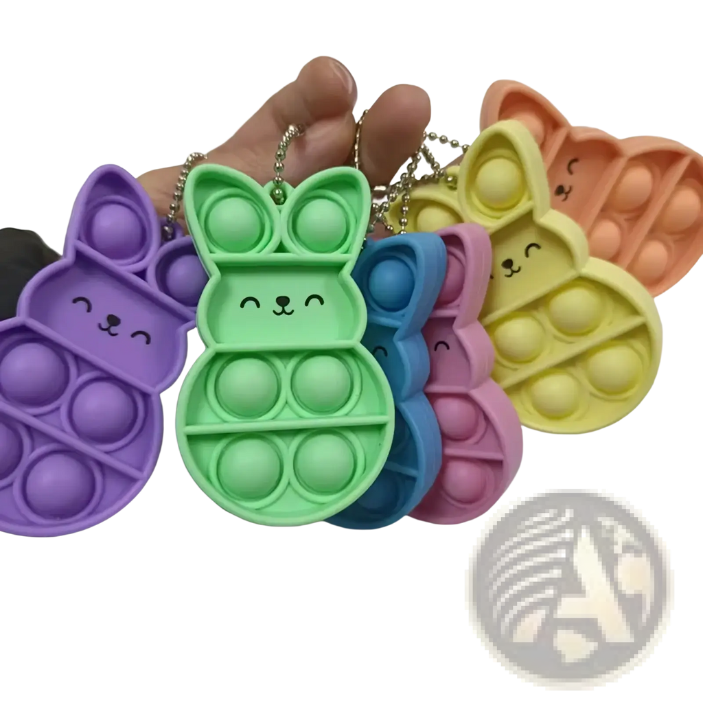 A collection of colorful pastel rabbit pop it fidget keychains in purple green blue pink and yellow for sensory play