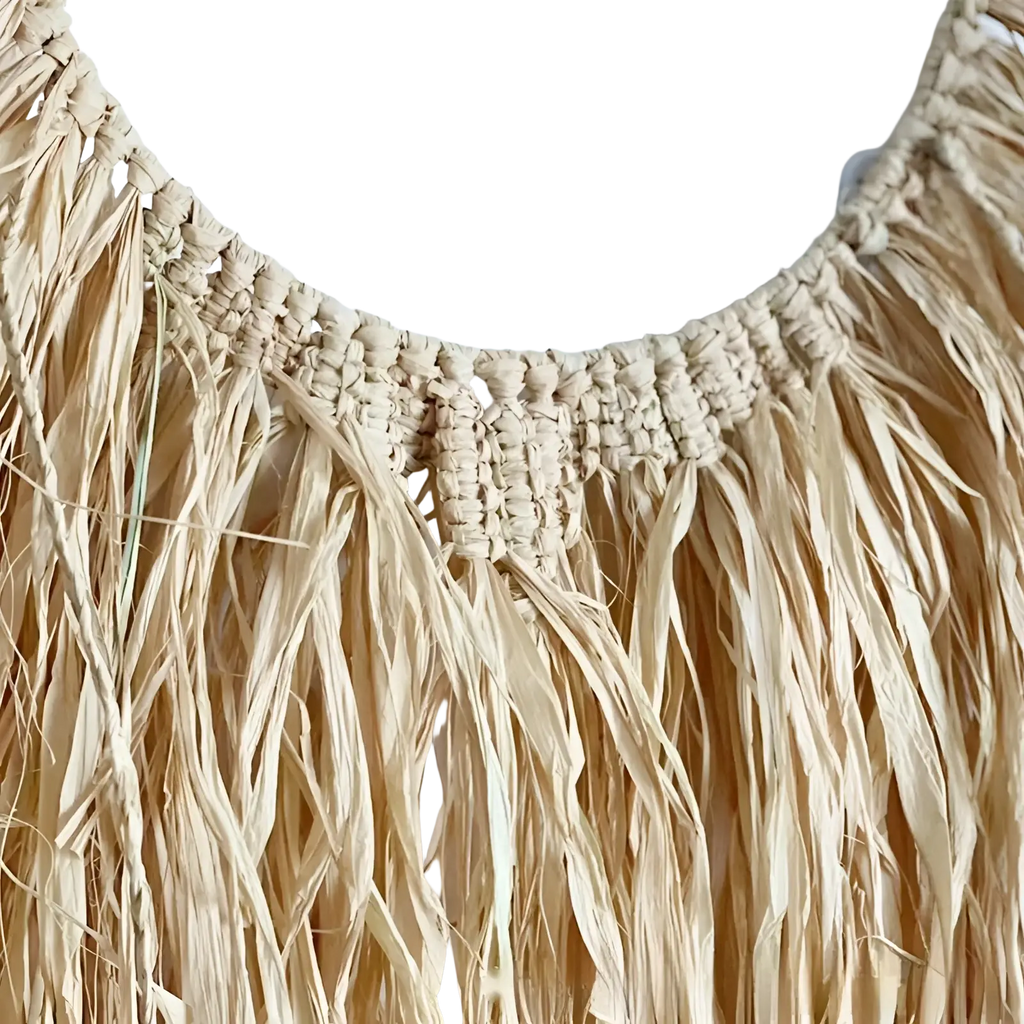Beige raffia boho macrame wall decor featuring woven straw fringe and a textured braided top edge hanging tapestry