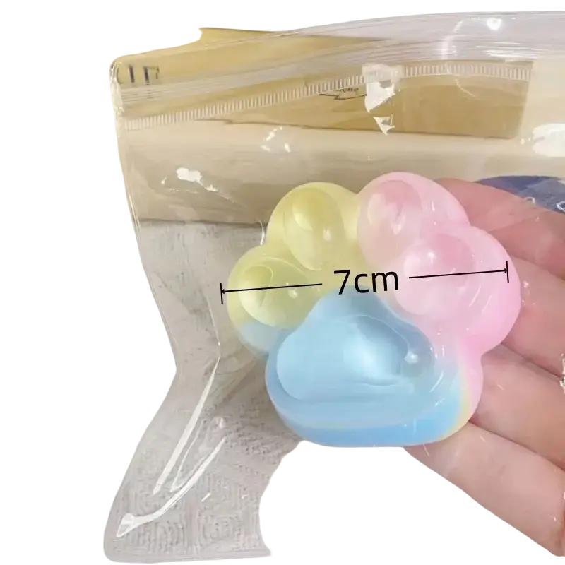 Pastel rainbow gradient silicone paw-shaped squishy fidget toy designed as a rainbow cat claw for stress relief
