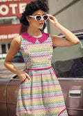 A vibrant sleeveless cotton dress with a colorful geometric pattern and bold pink peter pan collar