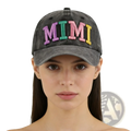 A faded gray baseball cap with mimi embroidered in colorful rainbow-striped letters on the front