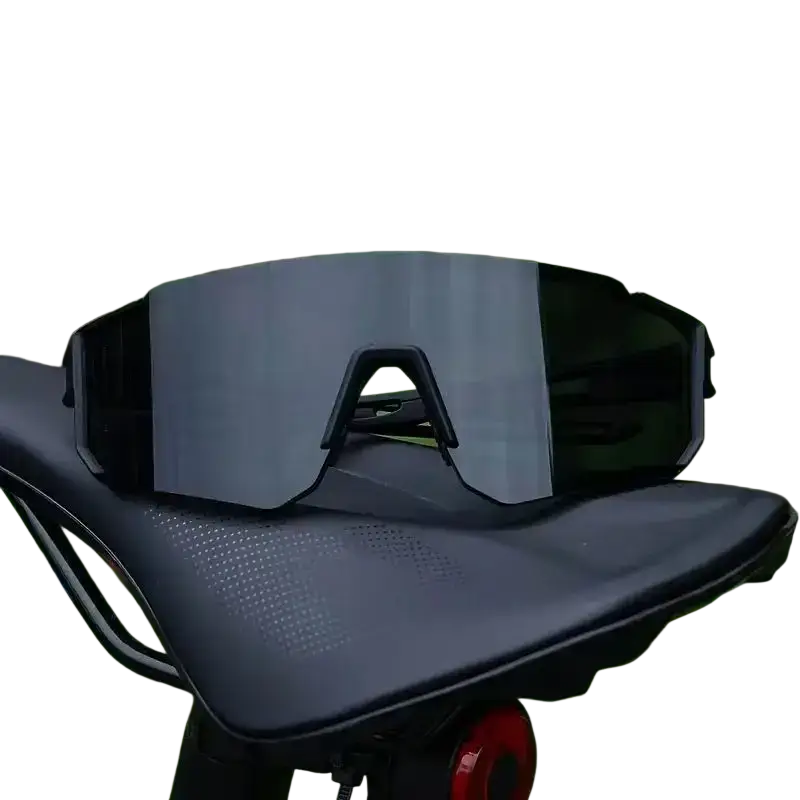 Black cycling sunglasses with sleek aerodynamic frame and gradient mirrored lenses resting on a bike seat