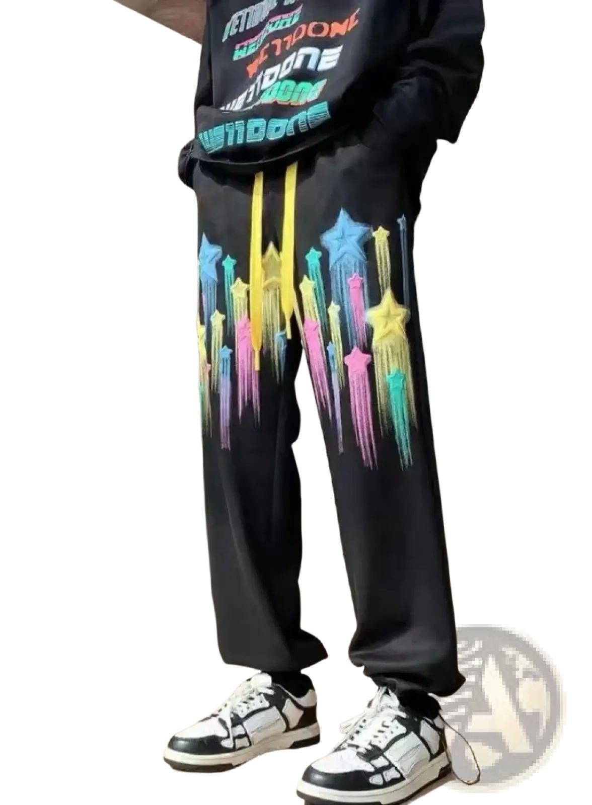 Black men sweatpants with vibrant rainbow star graphics dripping down the legs and bright yellow drawstrings