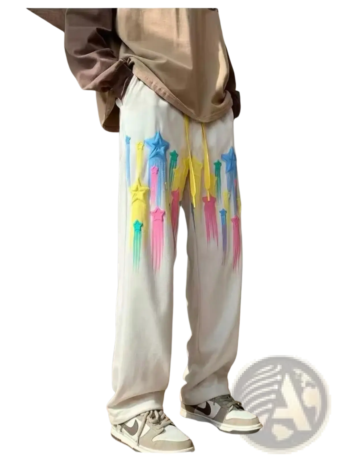 White sweatpants with vibrant dripping rainbow star graphics and yellow drawstrings in a men’s casual style