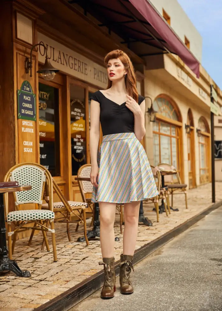 A woman wearing a rainbow stripe vintage cotton skater skirt with pastel diagonal stripes and a black top