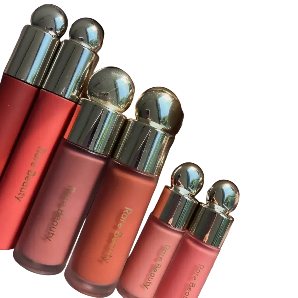 A set of rare beauty soft pinch liquid blush lip glosses in coral to peach gradient shades with silver caps and gold lettering