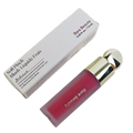 A sleek glass bottle of rare beauty soft pinch liquid blush in translucent pink with a gold cap and rare beauty branding