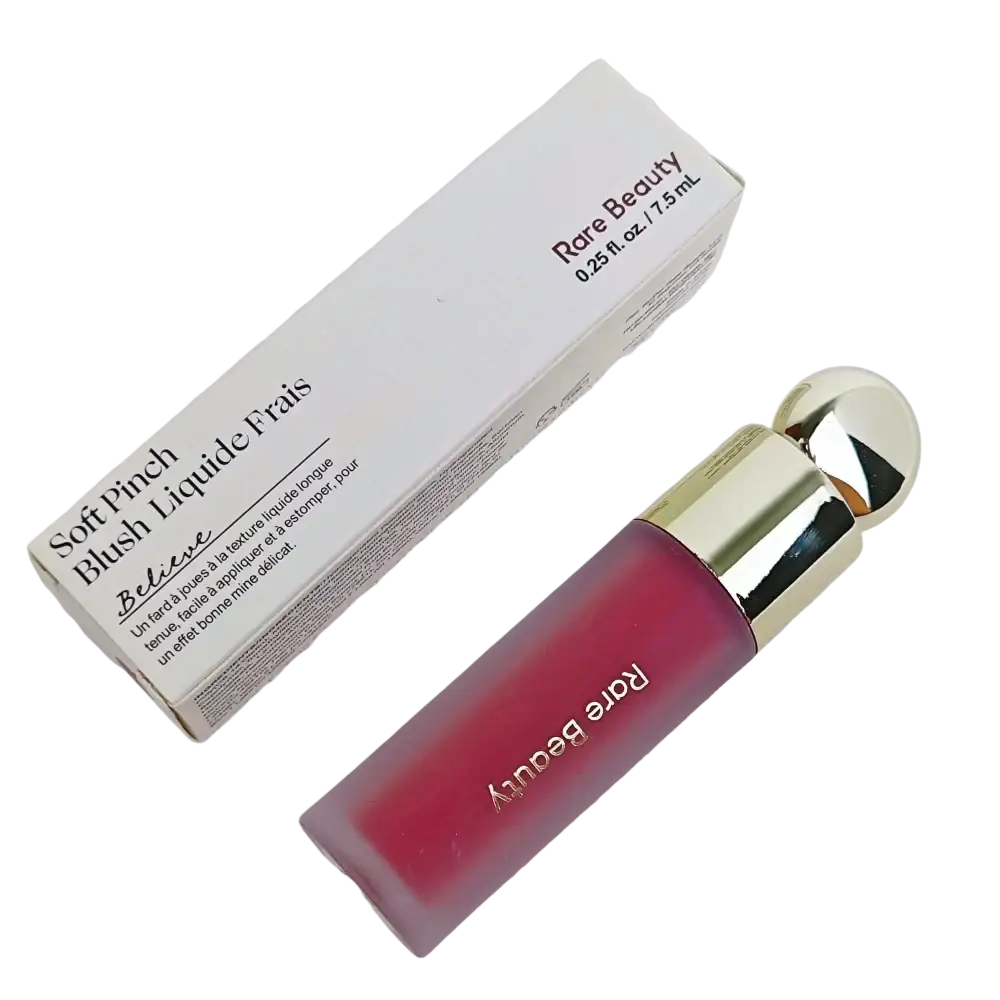 A sleek glass bottle of rare beauty soft pinch liquid blush in translucent pink with a gold cap and rare beauty branding