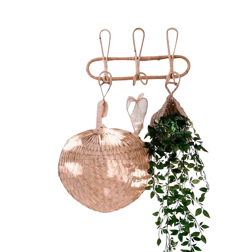 A light brown woven rattan kids wall hook set with three hooks for clothing storage and hanging