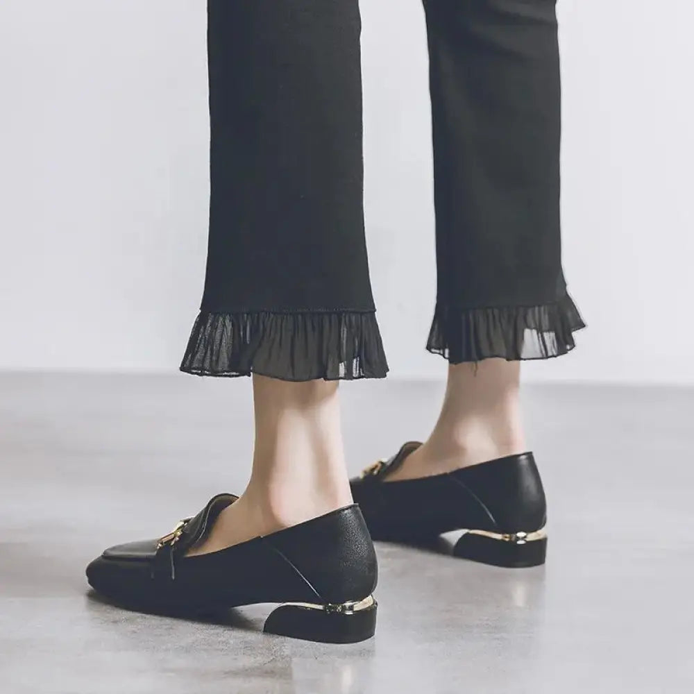 Black leather women’s British style horsebit loafers with gold-tone metal accents and sleek modern design